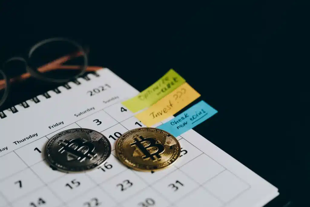 Monedas de criptoactivos sobre un cuaderno con apuntes de la resolución 000240 de 2025 de la DIAN
